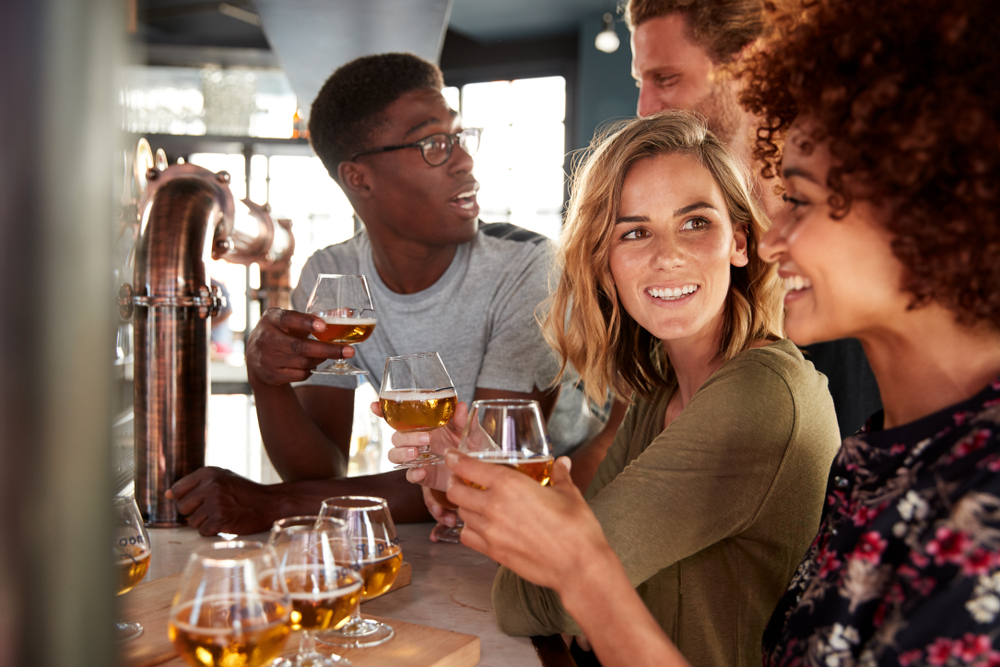 A group of friends smile as they try different brews at the best places to drink in the Big Easy.